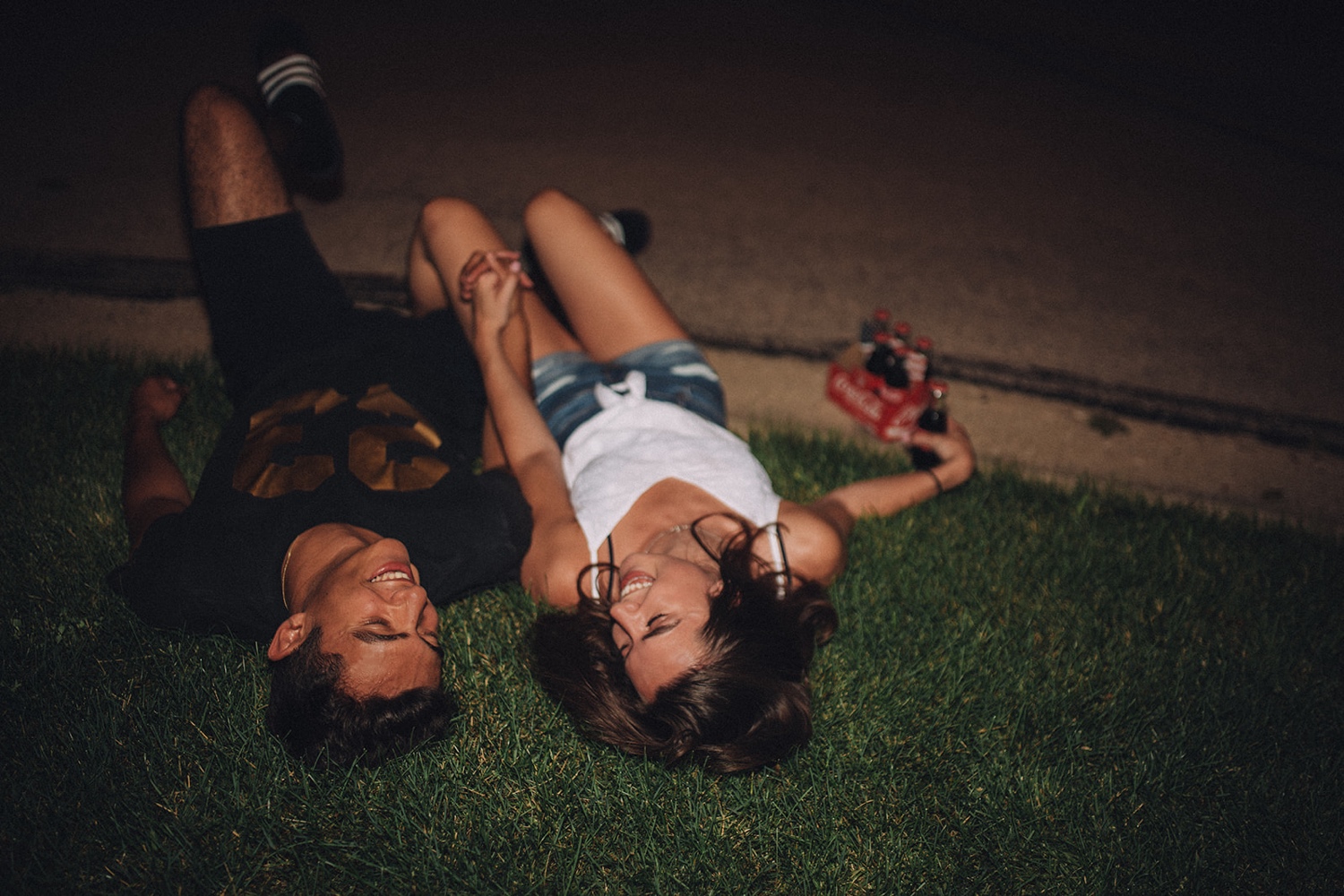 Couple lays in the grass at their date night