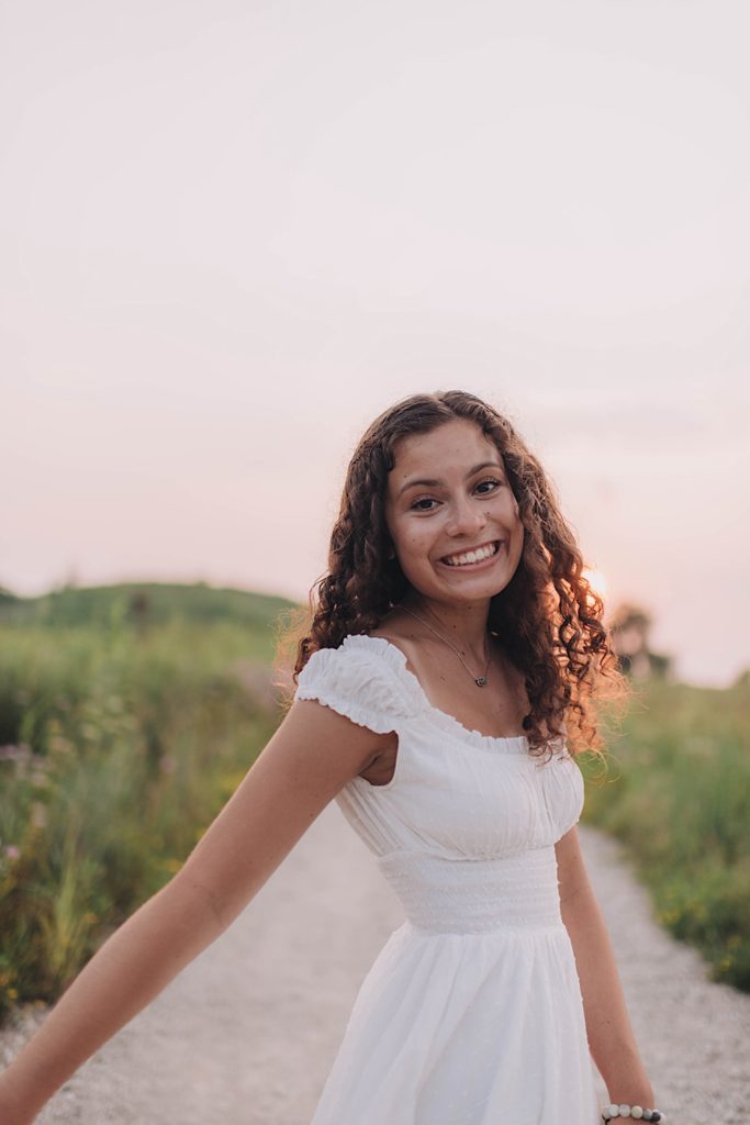 Senior portrait on path in forest preserve at sunset