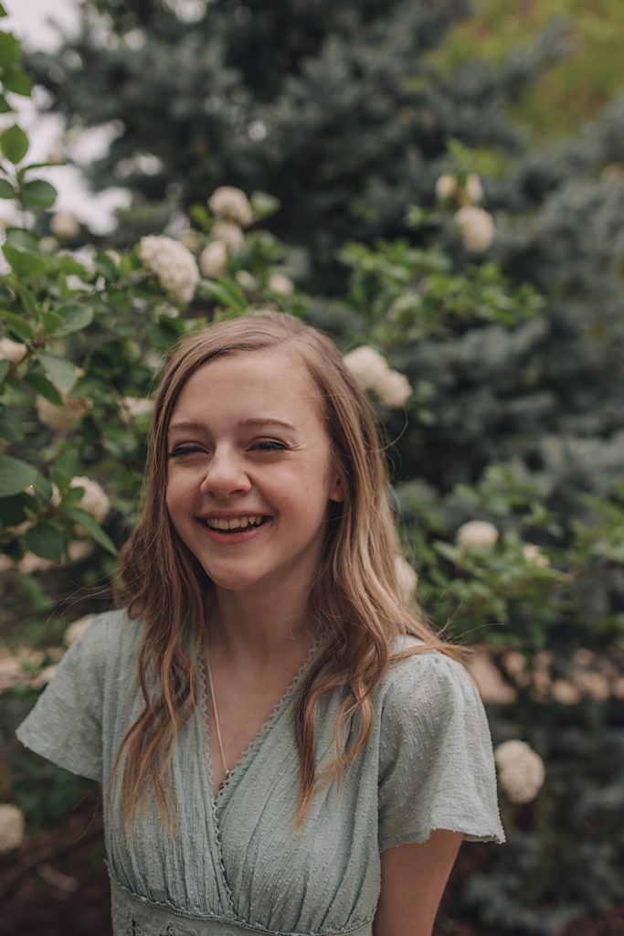 Senior picture in front of flowers taken at Adam's Park in Wheaton