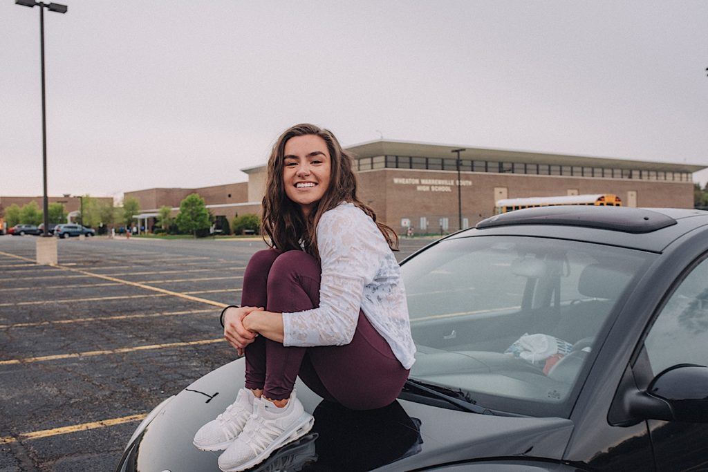 Senior sits on VW Bug at Wheaton Warrenville South