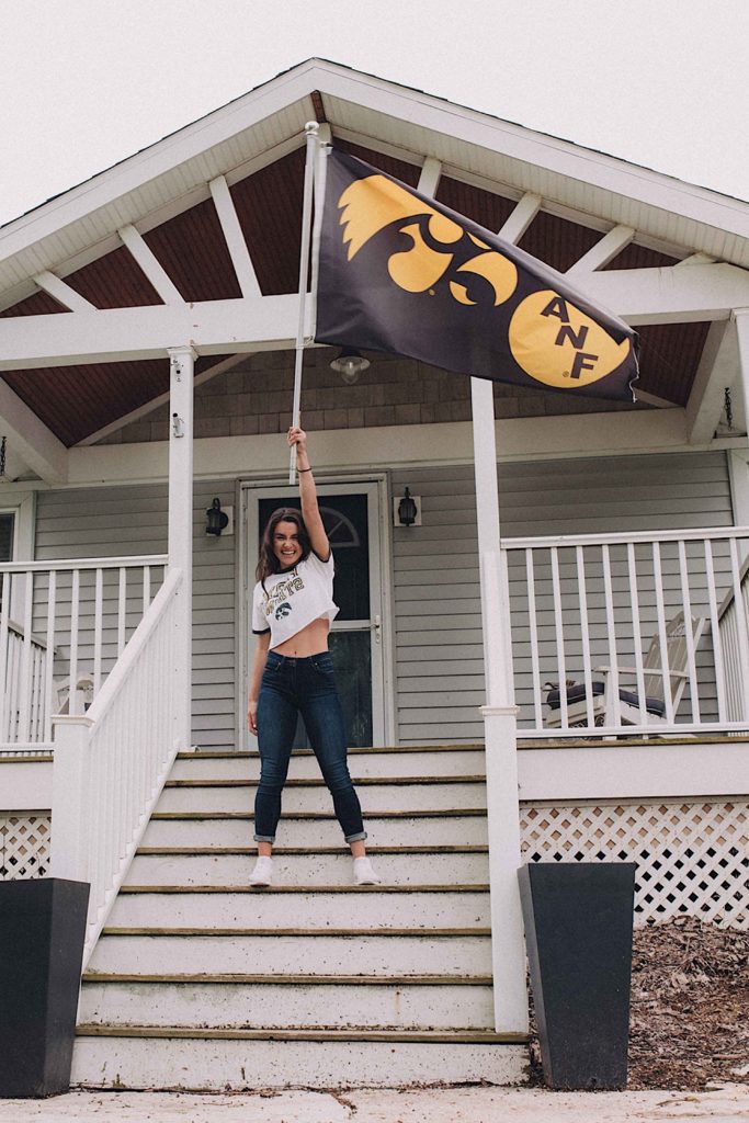 Senior shows of her college flag at home in Wheaton