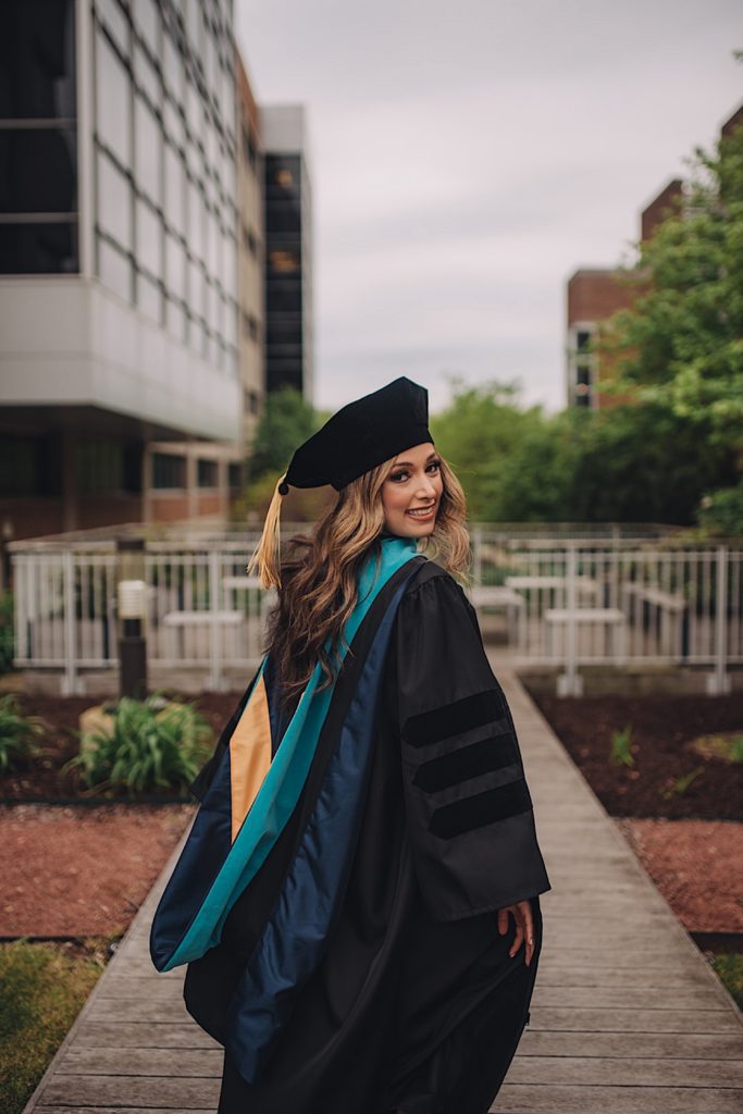 Grad shows off cap, gown and sash during graduation session